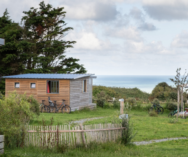 Un chalet du Camping Huttopia Les Falaises avec vue sur l'océan, près des falaises de Normandie